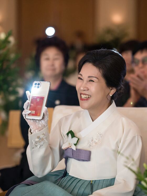 아펠가모 공덕 라로브홀에서 휴대폰으로 예식을 담는 어머님을 촬영한 본식스냅