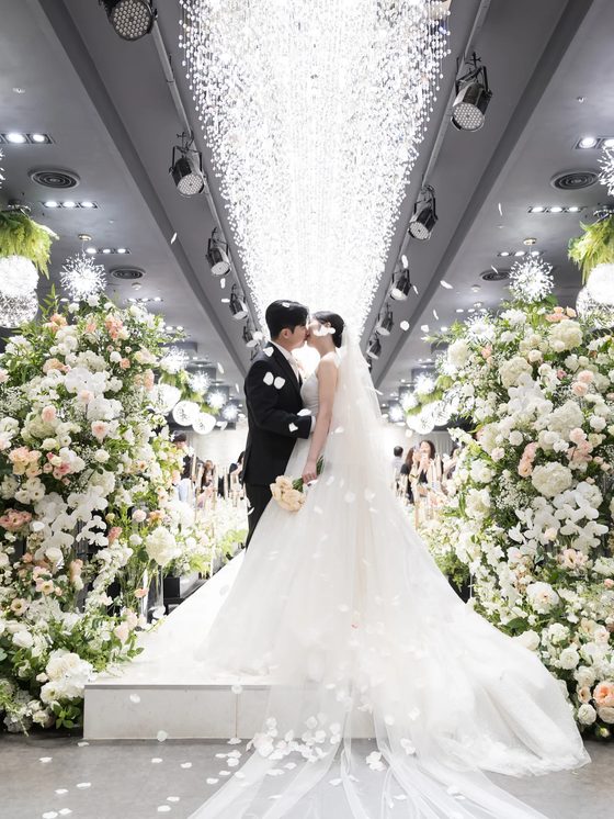 양재 브라이드밸리 입장 직전 문 사이로 보이는 신랑신부와 꽃 장식 본식스냅