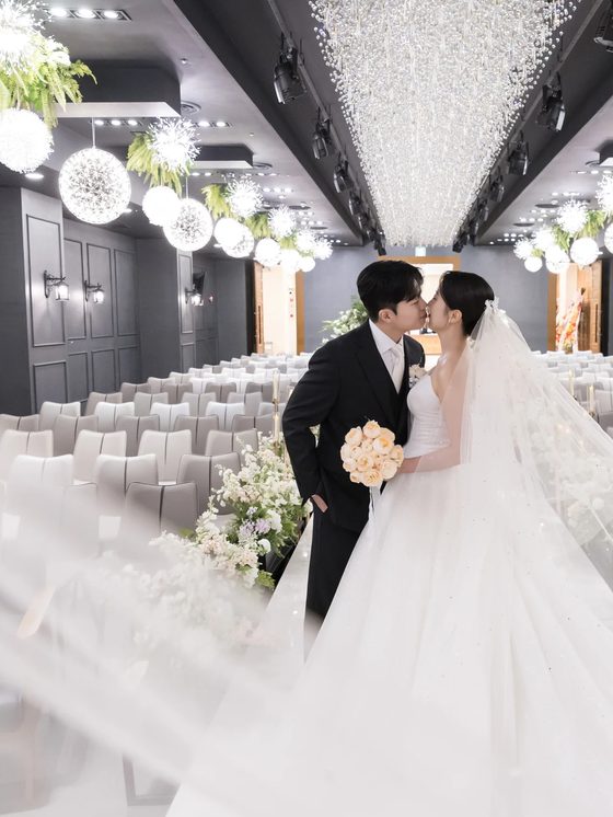 양재 브라이드밸리 홀에서 베일이 날리는 가운데 입을 맞추는 신랑신부 본식스냅
