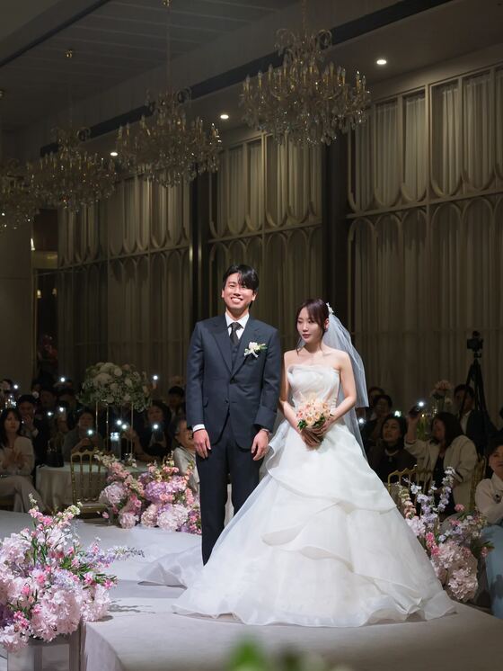 더리버사이드호텔 꽃 장식 앞에 선 신랑신부 본식스냅